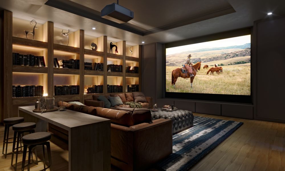 A luxurious home theater room featuring a large projection screen, hidden surround sound speakers, and comfortable seating with ambient lighting.